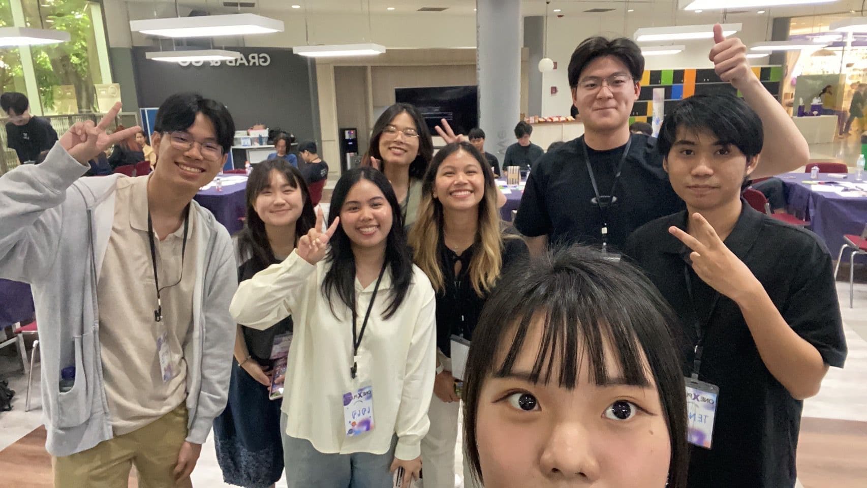 A group of teammates and peers smiling together at a technology event